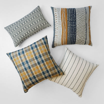 A 24" x 24" rectangular decorative throw pillow with plaid, striped and geometric patterns in navy, mustard, gray and cream.