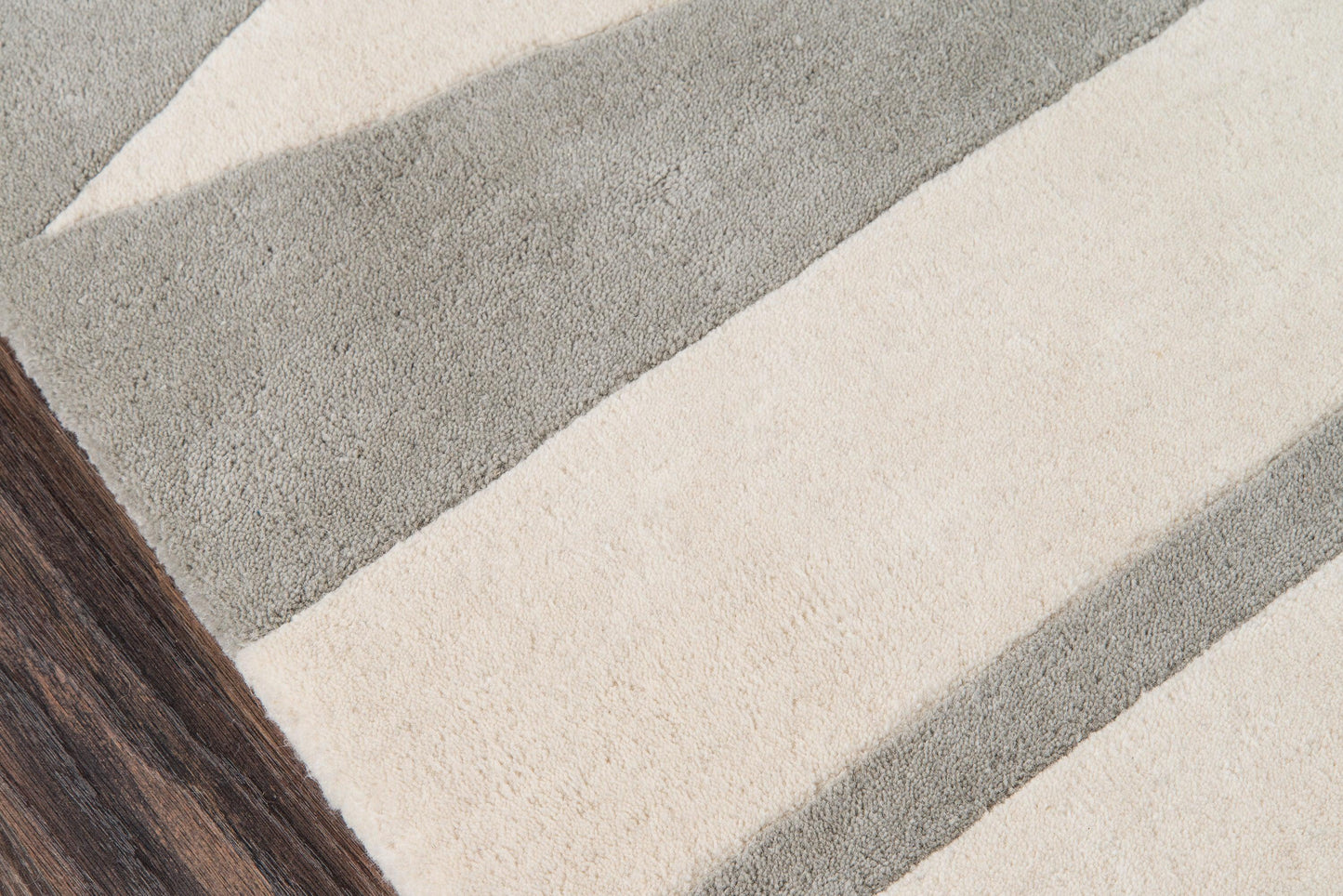Rectangular plush rug, 8' x 10', with bold beige & gray stripes; modern, cozy look on dark wood floor.