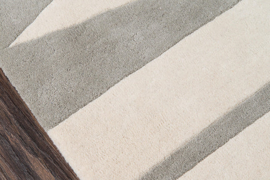 Rectangular plush rug, 8' x 10', with bold beige & gray stripes; modern, cozy look on dark wood floor.