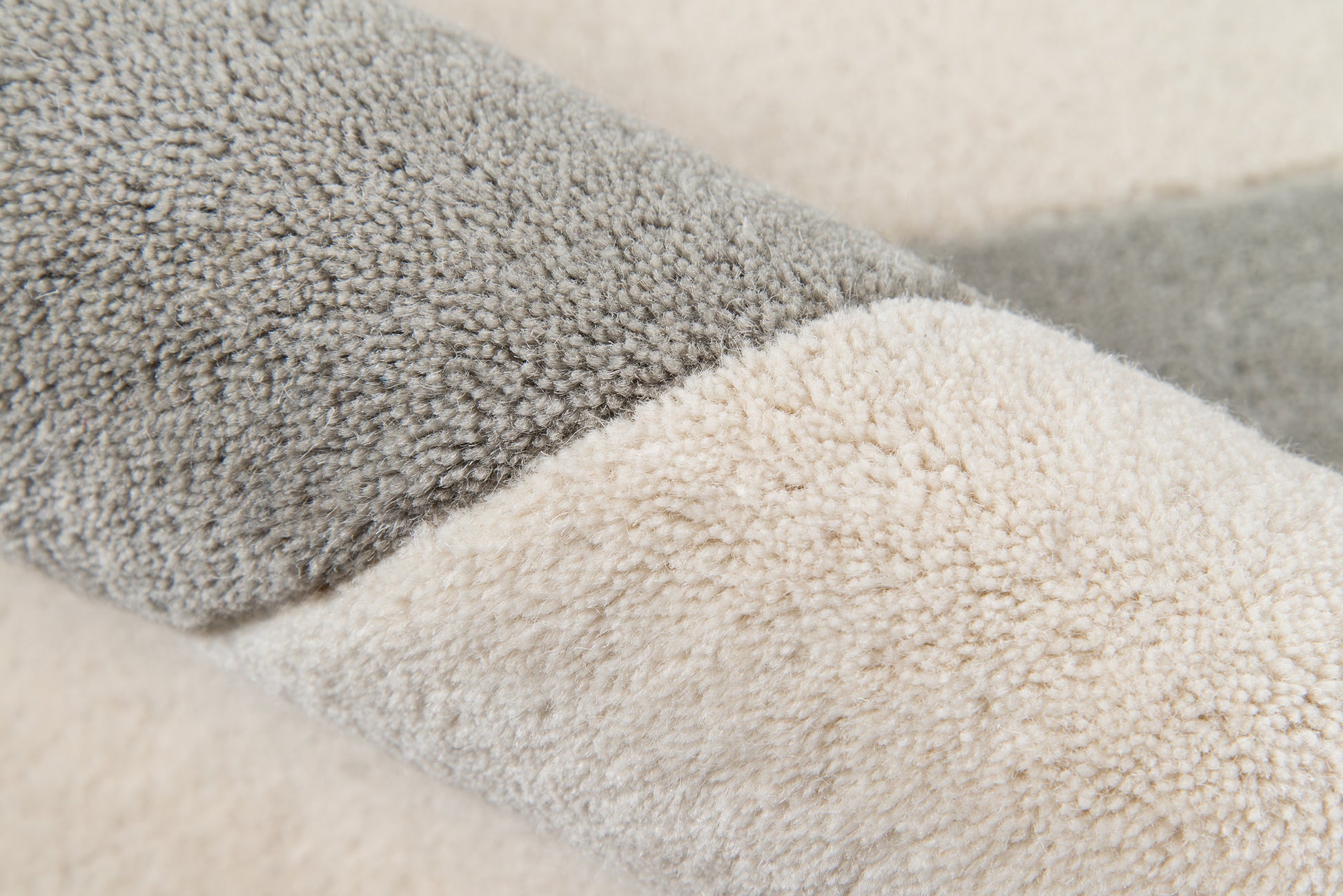 Close-up of plush two-tone sherpa pile in gray and beige on an 8' x 10' rug.