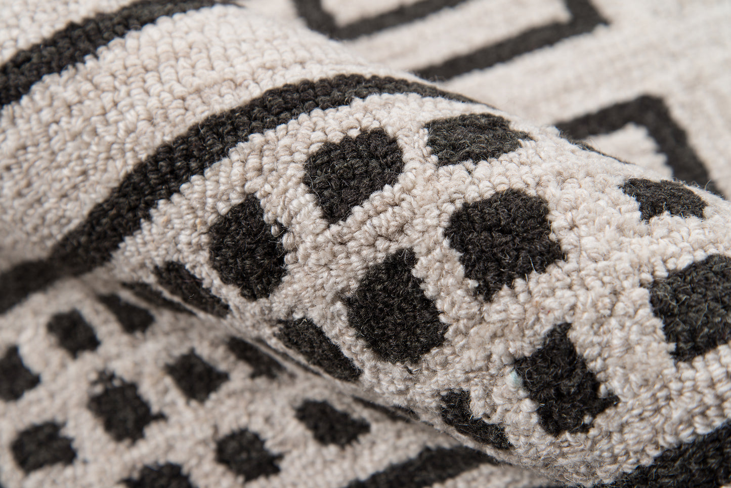 Beige tufted rug with black leopard spots & bold border; soft loop-pile for living room decor.