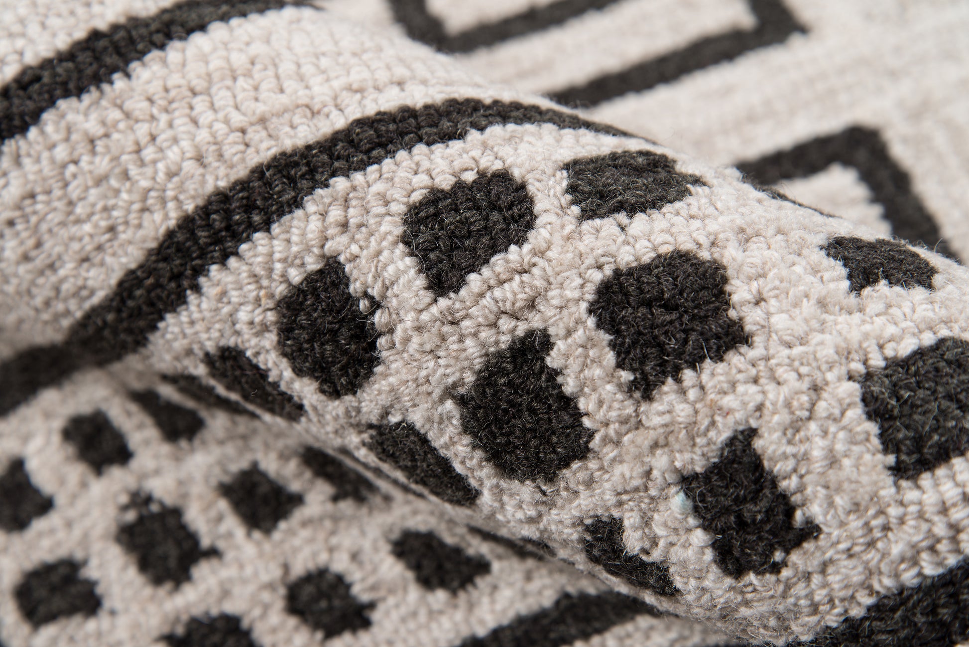Beige tufted rug with black leopard spots & bold border; soft loop-pile for living room decor.