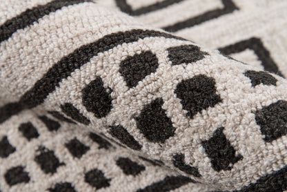 Beige tufted rug with black leopard spots & bold border; soft loop-pile for living room decor.