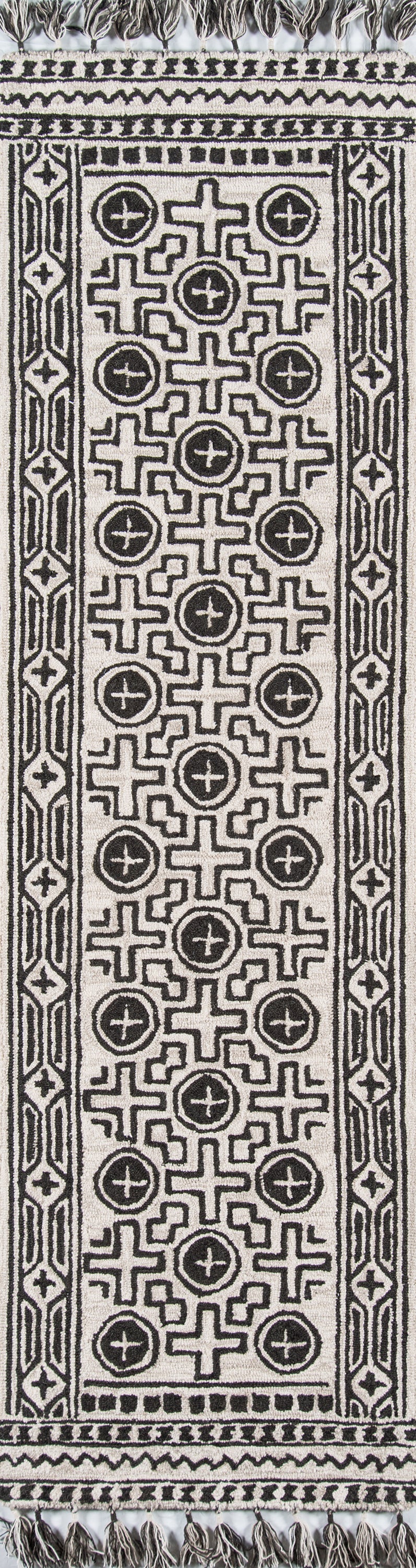 Black and ivory woven cotton runner rug with bold geometric cross and circular motifs, bordered by patterned trim and fringe.