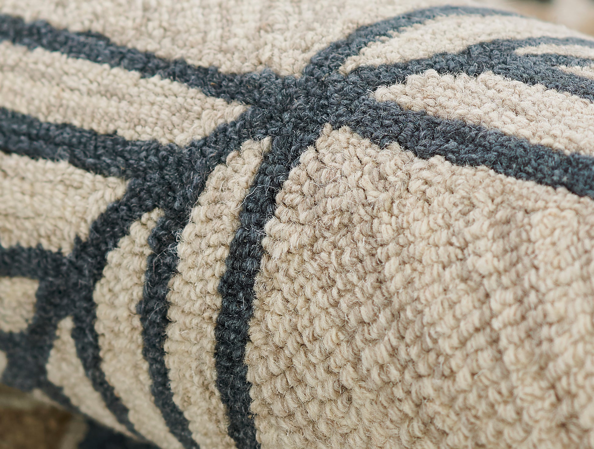 Beige textured rug with dark blue geometric lines and boucle loop-pile texture.