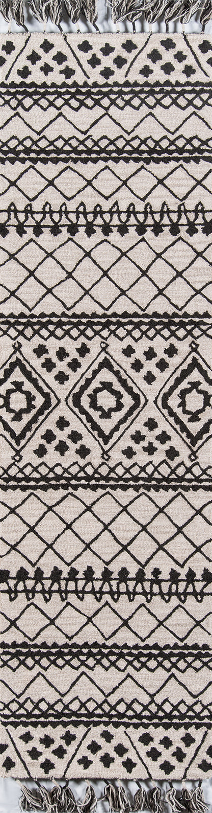 Beige woven rug with bold black geometric tribal print, diamonds and lattice motifs, tassel fringe along edges.