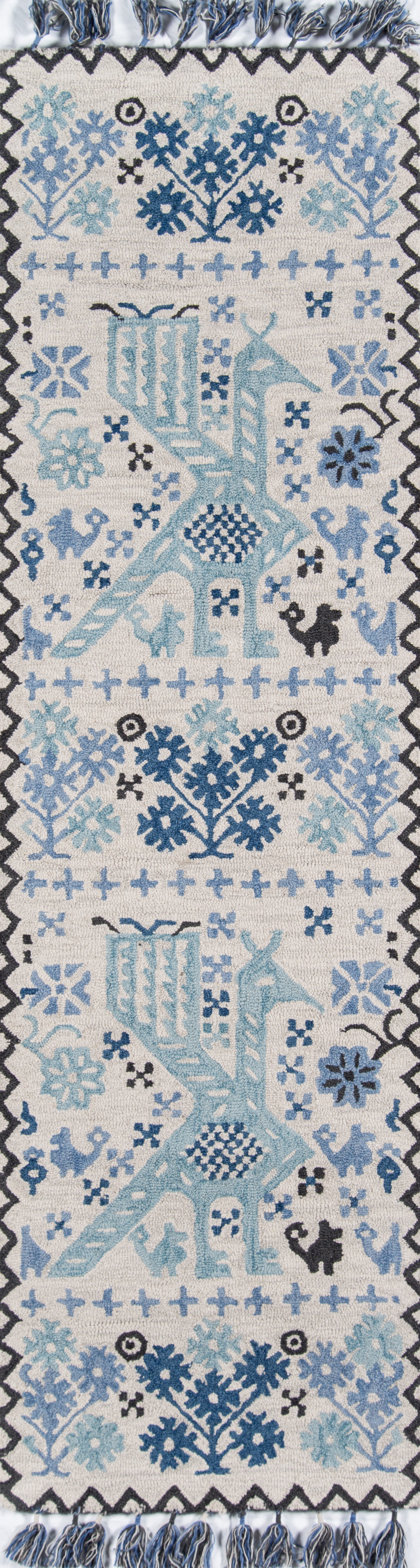 Blue-and-white cotton woven runner rug with snowflake motifs, a central stylized bird, geometric border, fringe.