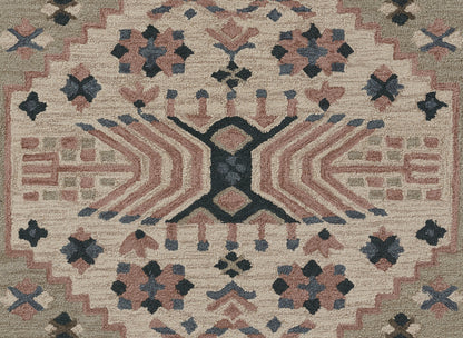 Tahoe-style beige geometric area rug with pink, navy and gray motifs, central X motif and zigzag border.