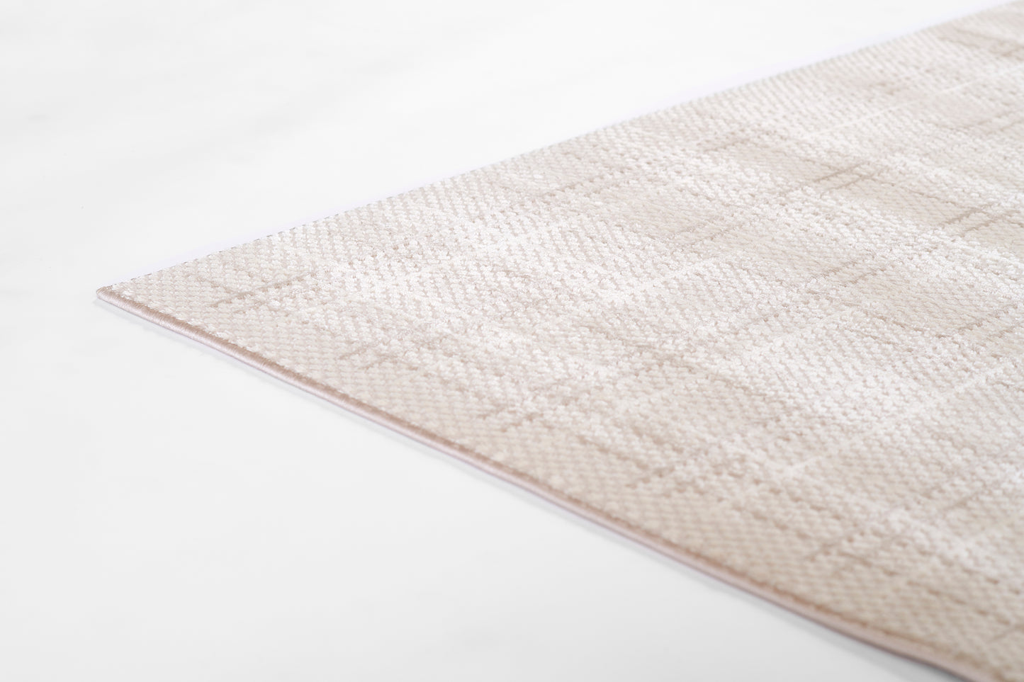 Beige woven area rug with subtle geometric pattern, low-pile texture and neutral cream tones.