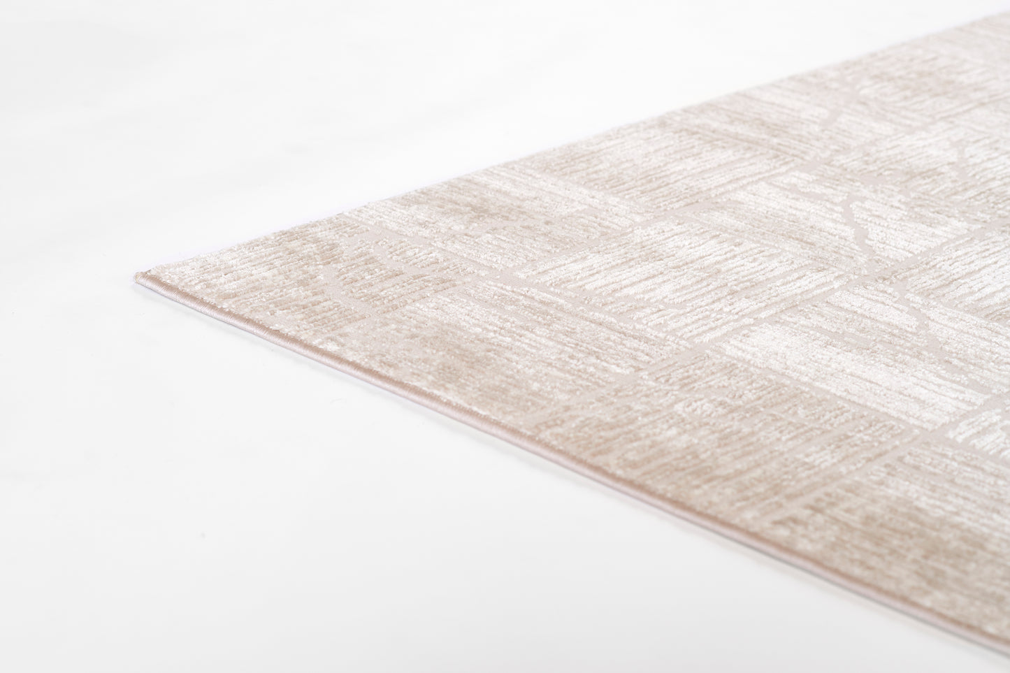 Beige rug with subtle geometric pattern and soft texture, corner edge visible.