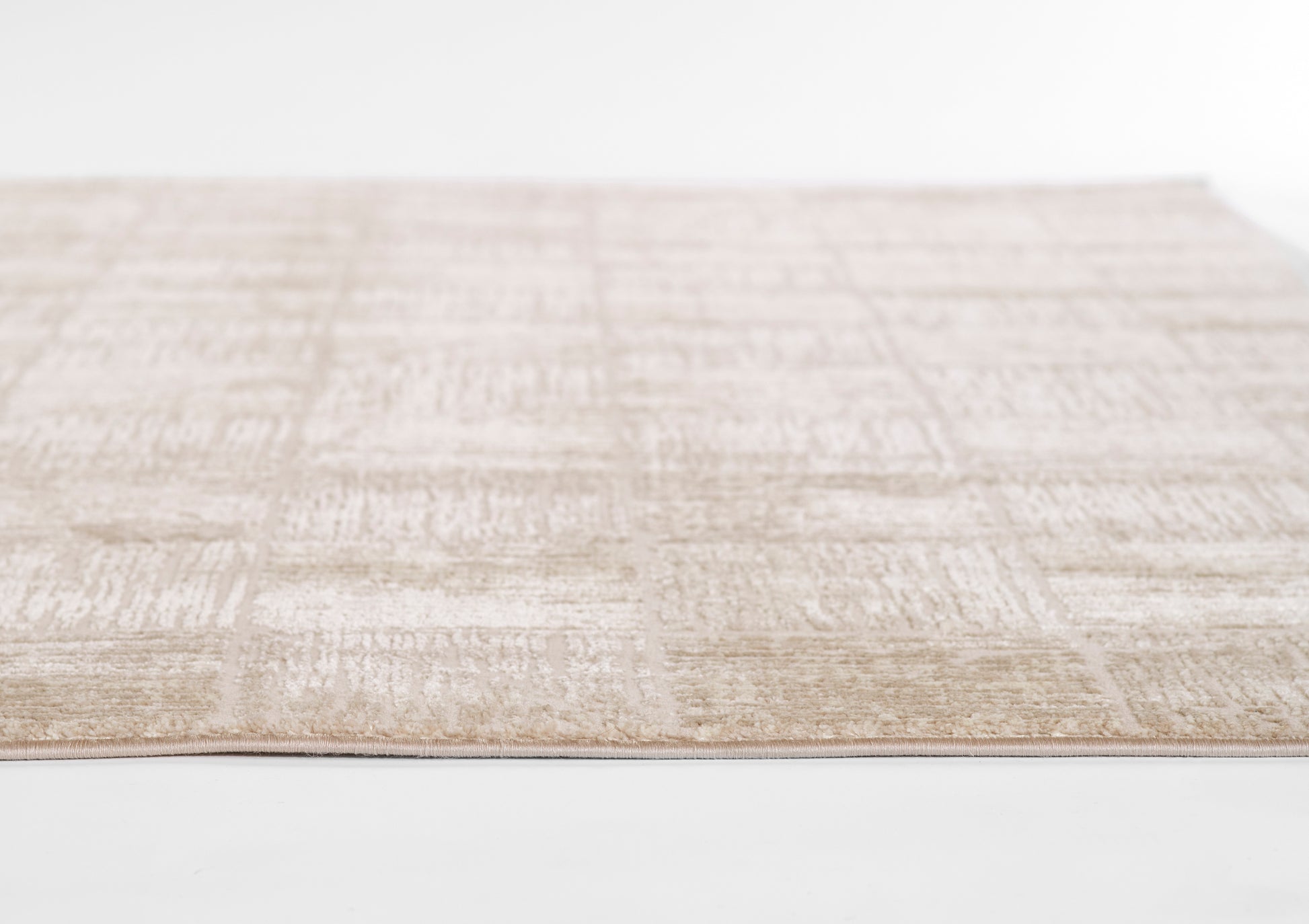Beige textured flat-weave rug with subtle geometric blocks, rectangular, neutral tones for living room decor.