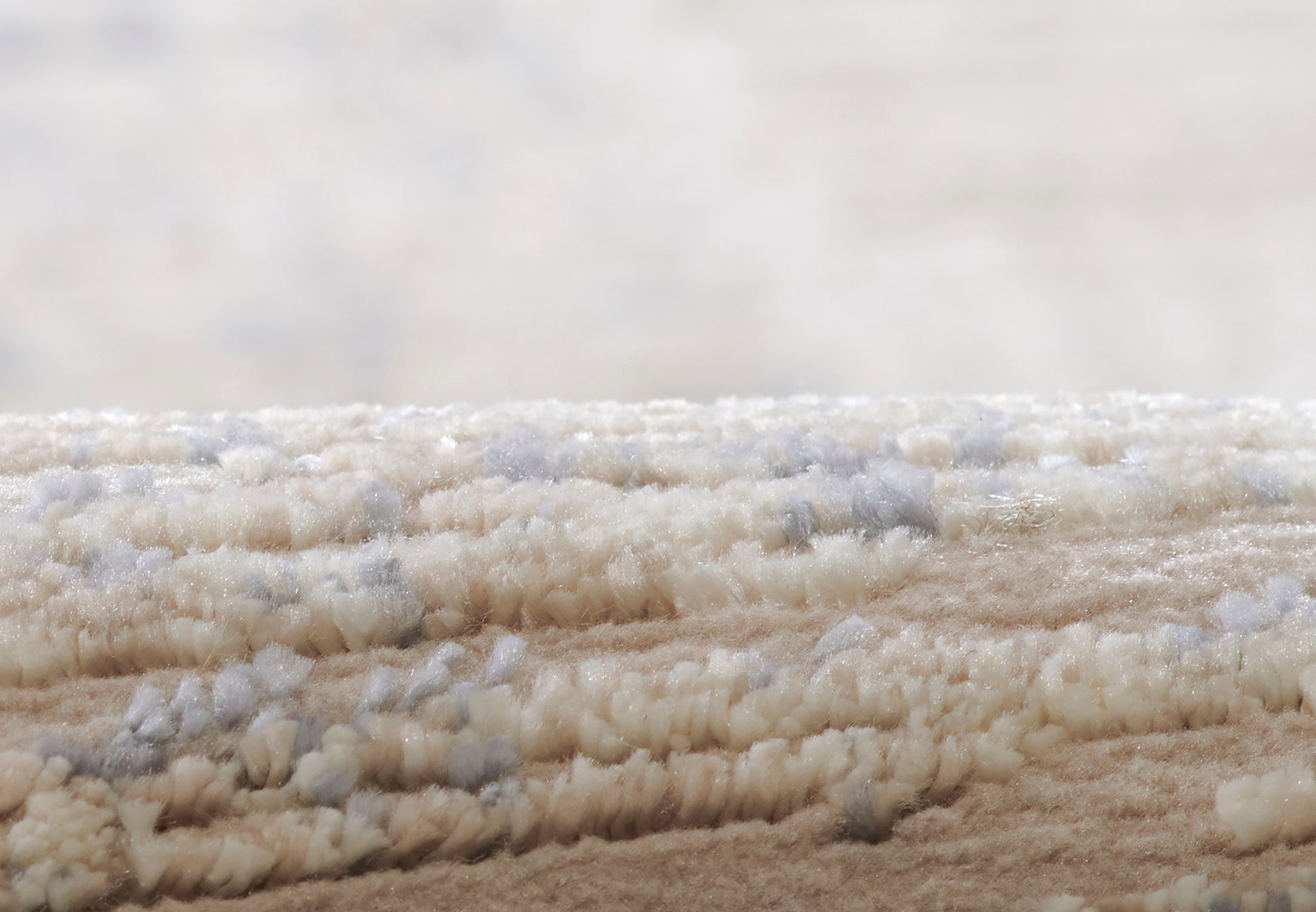 Cream beige shag rug with plush looped pile and subtle blue-gray flecks, soft textured decor.