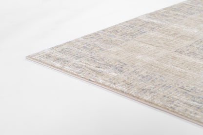 Rectangular beige area rug with pale blue distressed pattern, soft low-pile texture and pink-tinted edge.