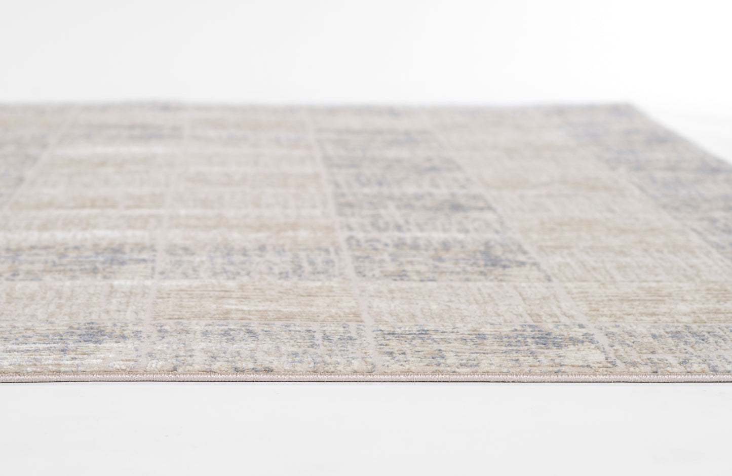 Beige patchwork area rug with muted blue distressed motifs; rectangular, woven texture, versatile living room decor.