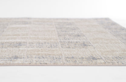 Beige patchwork area rug with muted blue distressed motifs; rectangular, woven texture, versatile living room decor.