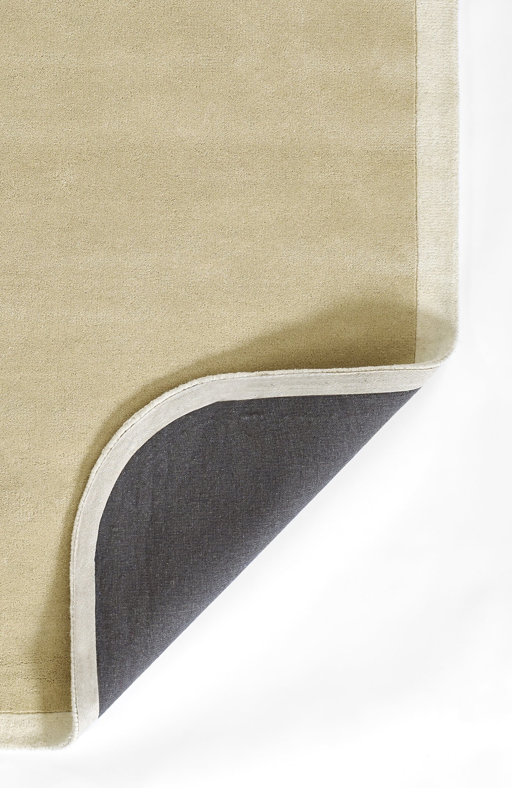 Beige rug with light gray edging; curved corner flipped to reveal dark gray underside.