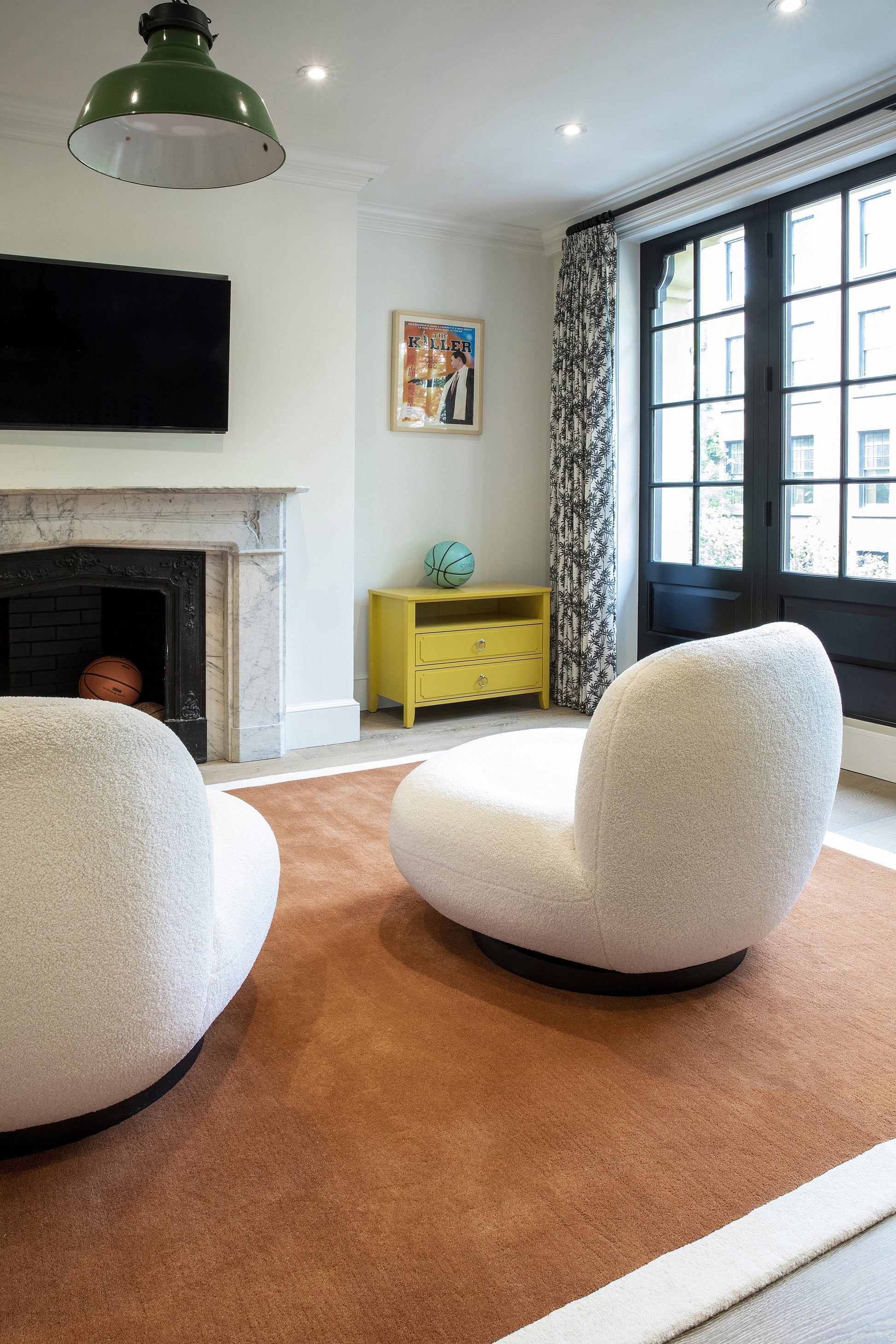 Brown rug runner on the floor in a bright living room with a marble fireplace and a yellow side cabinet.