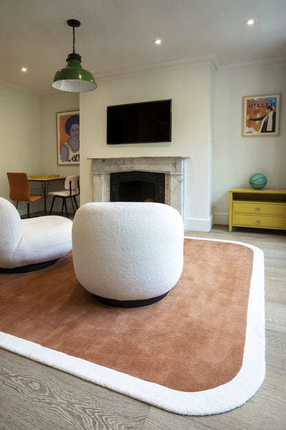 Two-tone rug: brown center with plush white border, modern living room scene.