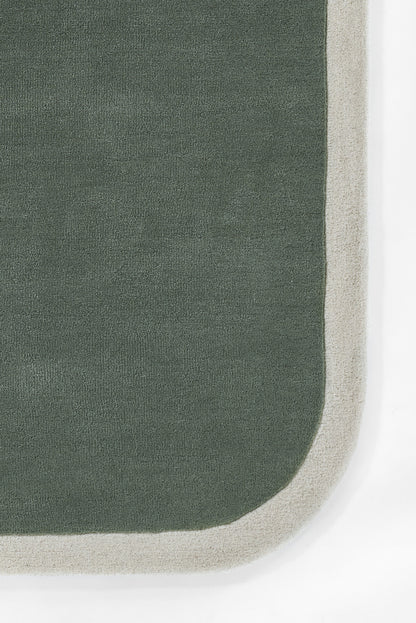 2' x 4' dark green rug with light beige border & rounded corner; soft, woven textile.