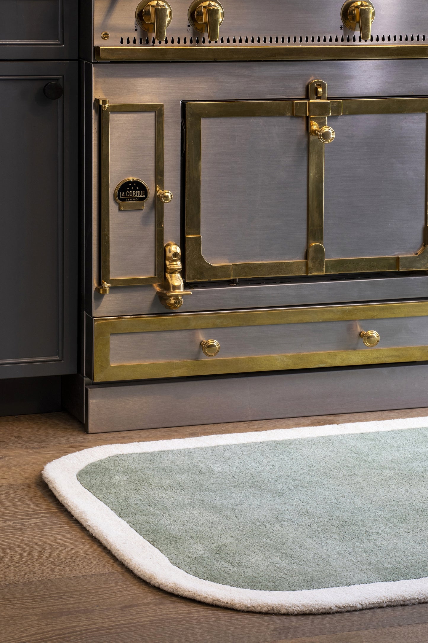 Pale green rug on dark wood floor, 8' x 10'.