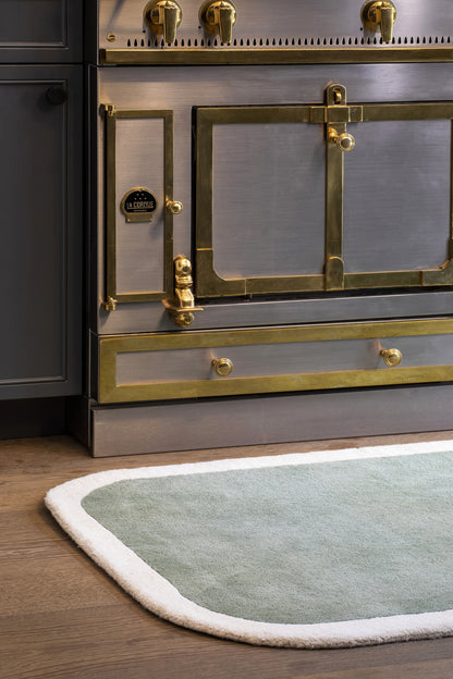 Pale green rug on dark wood floor, 8' x 10'.