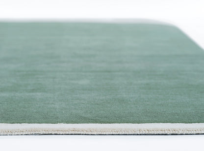 Green rectangular rug with a light beige fringe edge, flatwoven texture in a casual modern style.