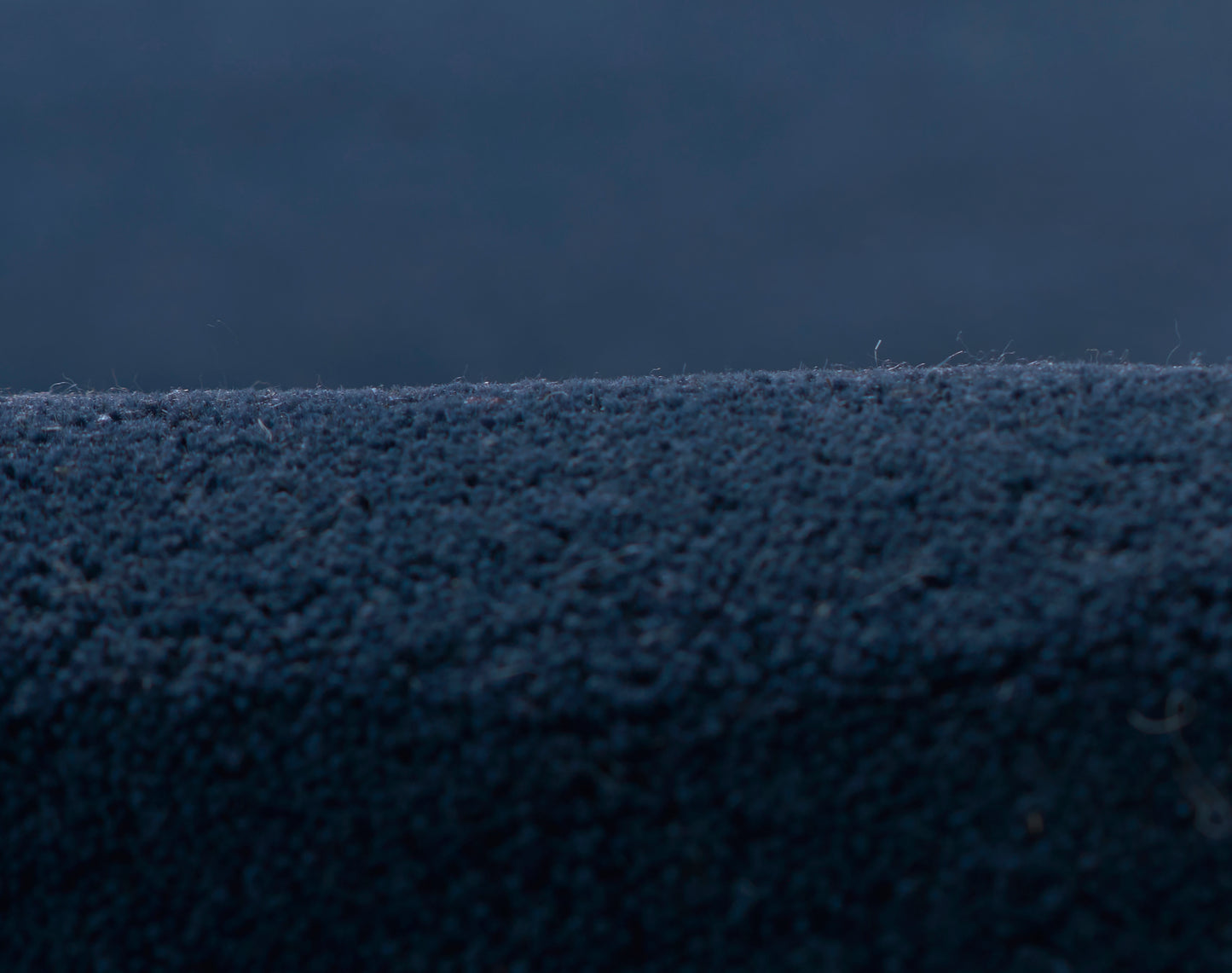 Close-up of navy blue velvet rug runner with soft, plush pile and fine texture.
