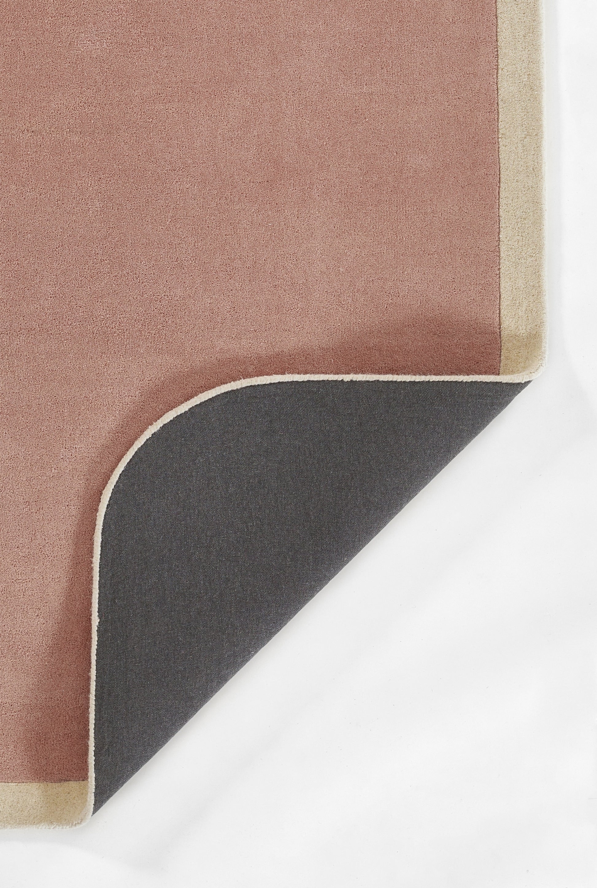 Soft pink throw blanket with beige edge trim and dark charcoal reverse, corner folded to reveal two-tone design.