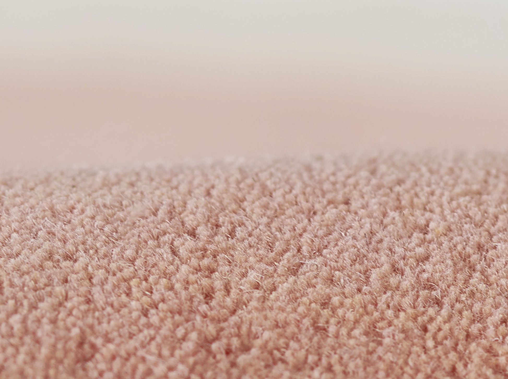 Close-up of a soft pink shag rug with plush pile, cozy home decor.