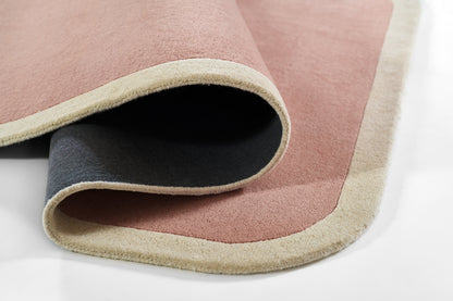 Soft pink rug with cream fringe and dark underside, thick pile, rolled edge; modern cozy home floor rug