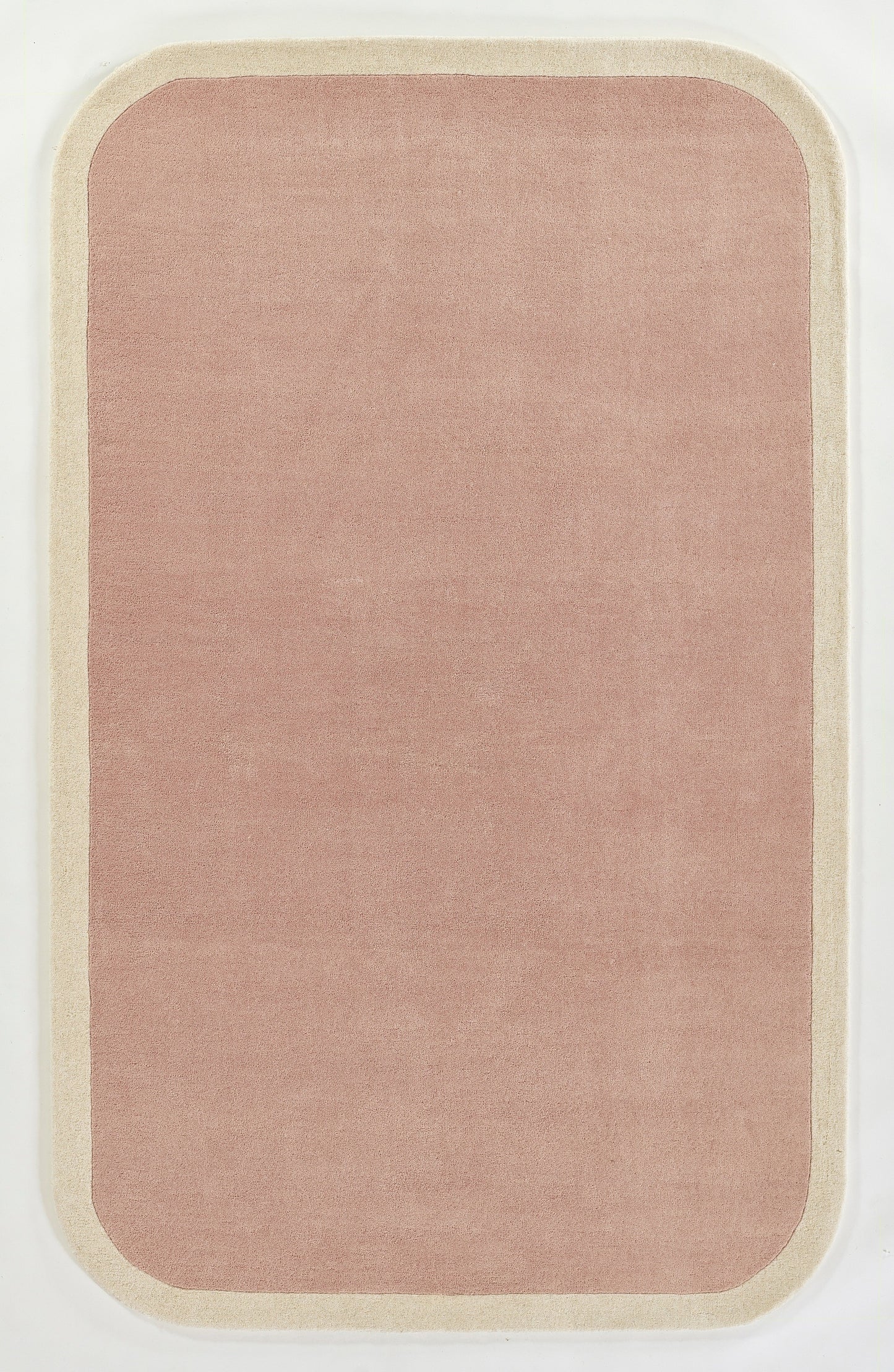 Soft pink rounded-rectangle rug with cream border; plush pile for cozy living room decor.