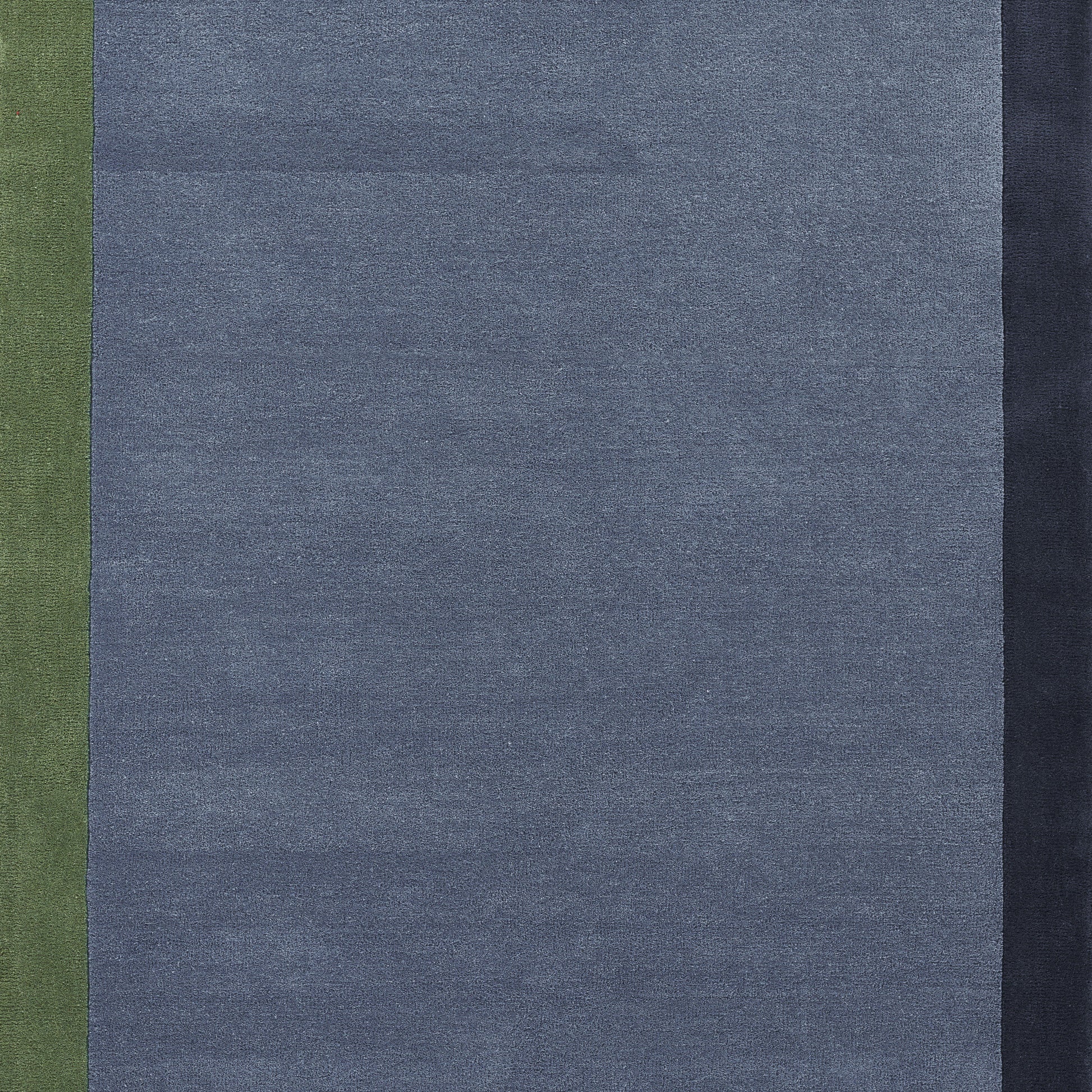 Blue woven rug (4' x 6') with olive green left stripe and dark navy right edge; denim-inspired design.