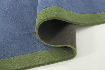 Blue plush rug with lime-green border, folded at the corner to reveal the dark underside.