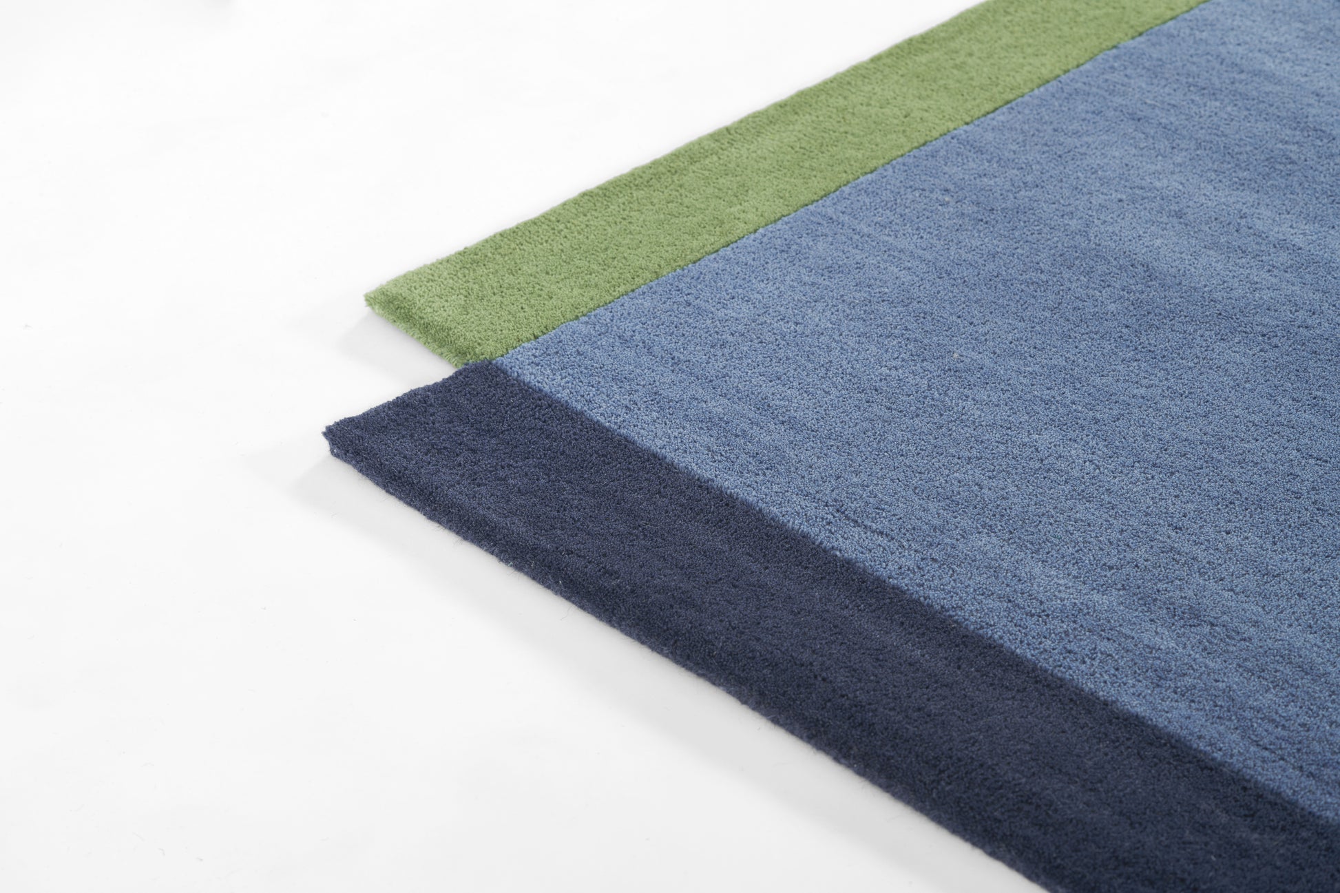 Rectangular plush runner rug with three color bands: green edge, light blue center, navy border; soft tufted texture.