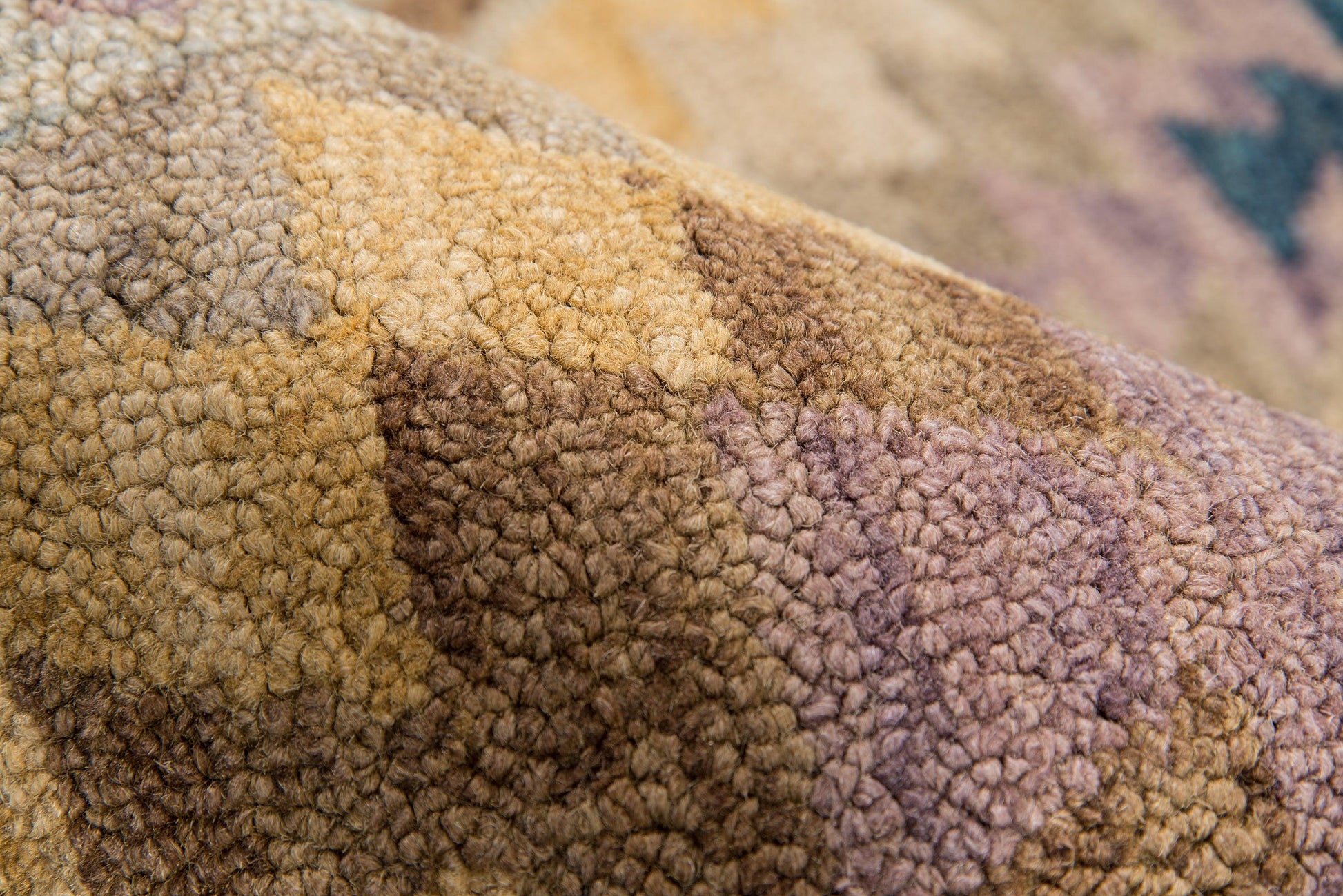 Close-up of a chunky boucle rug in earthy browns, tans, beige and lavender, with a textured, cozy floor covering.