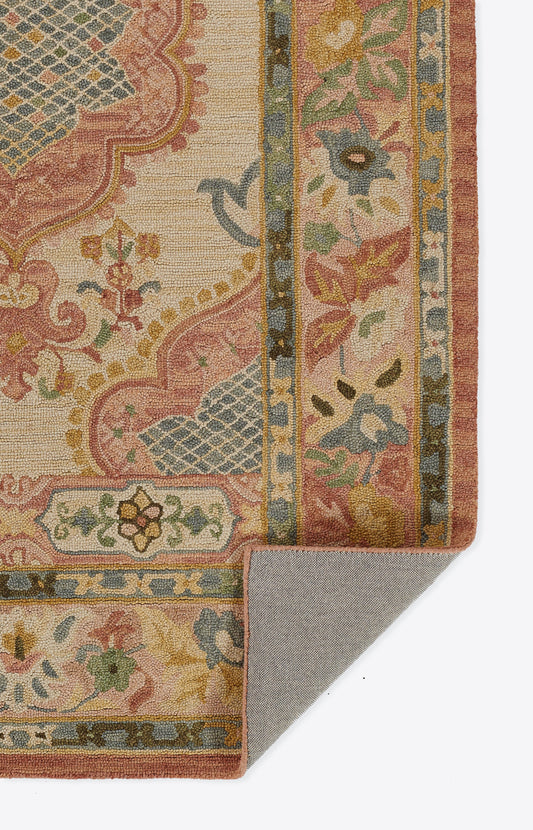 Oriental floral rug in pink, ivory, blue and green with decorative border; woven texture, folded corner reveals backing.