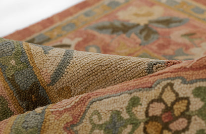 Close-up of a thick-pile, textured oriental rug with floral pattern in rust, olive, beige and blue tones.