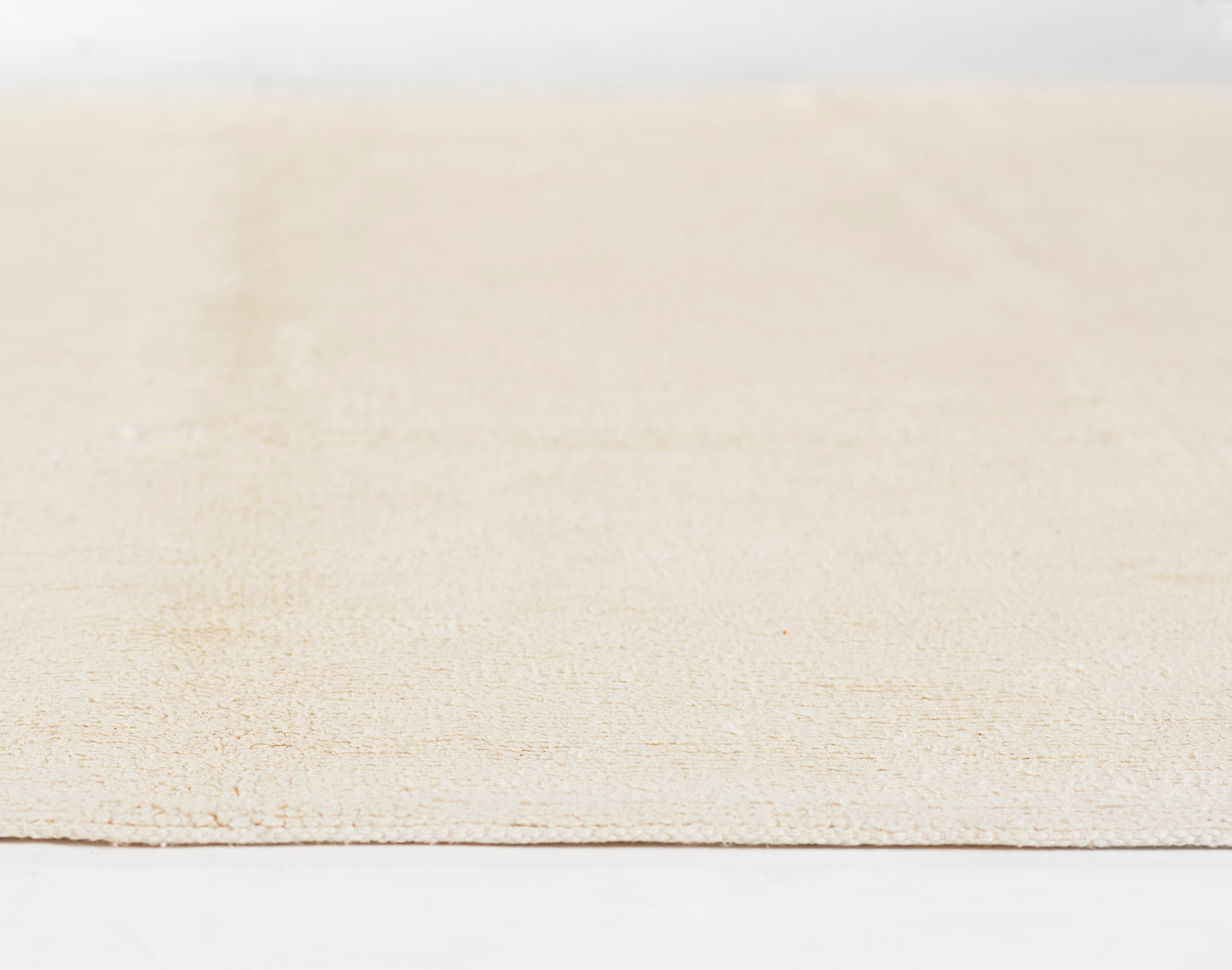 Ivory beige textured rug with subtle pattern, low-pile weave, rectangular shape for casual living spaces.