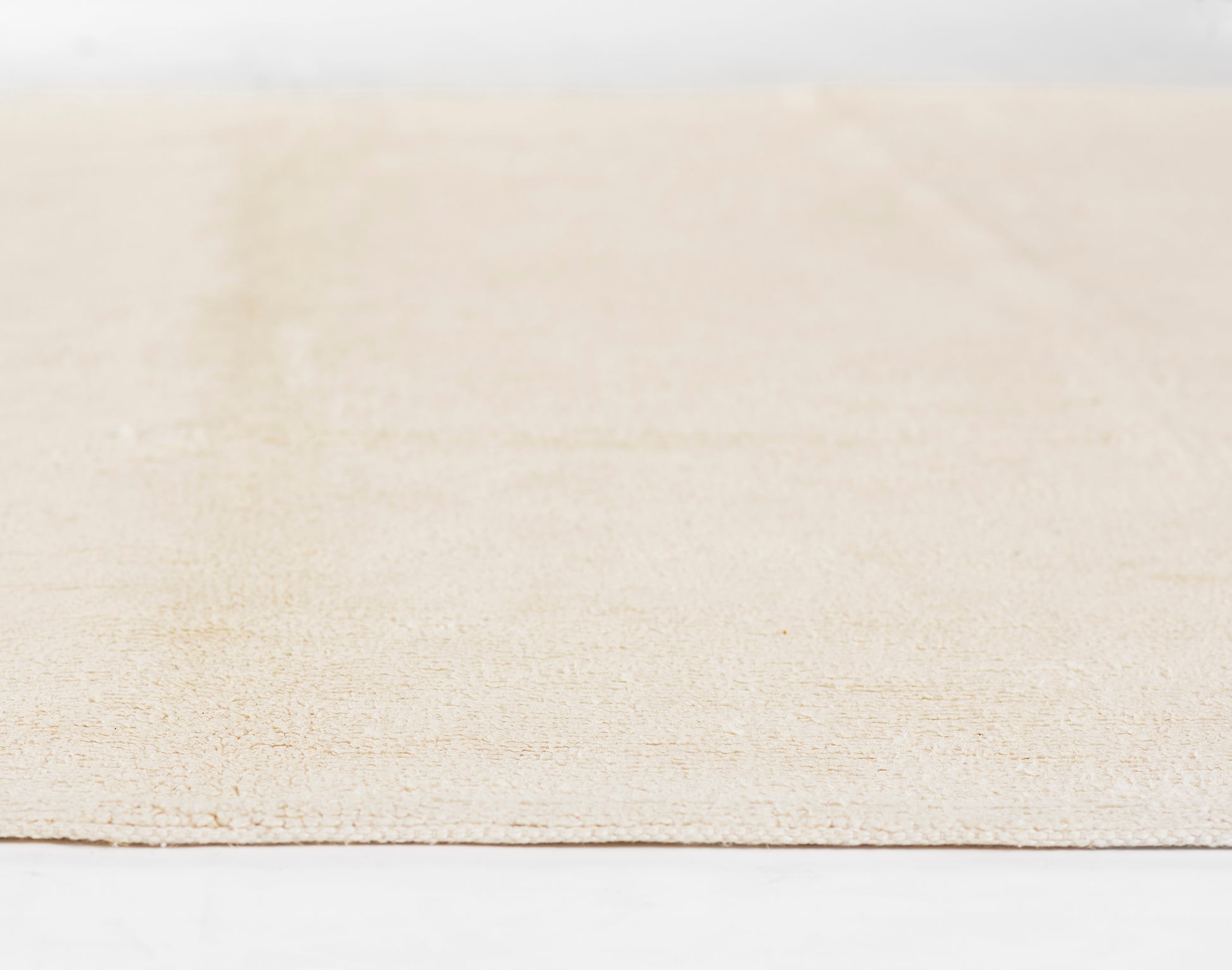 Ivory beige textured rug with subtle pattern, low-pile weave, rectangular shape for casual living spaces.