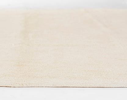 Ivory beige textured rug with subtle pattern, low-pile weave, rectangular shape for casual living spaces.