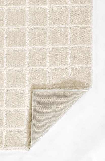 Beige plush rug with square grid pattern; corner lifted to reveal soft woven underside.