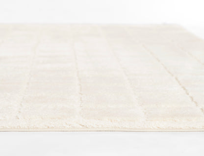 Cream rug with subtle texture, fringed edges, rectangular shape for living room or bedroom.