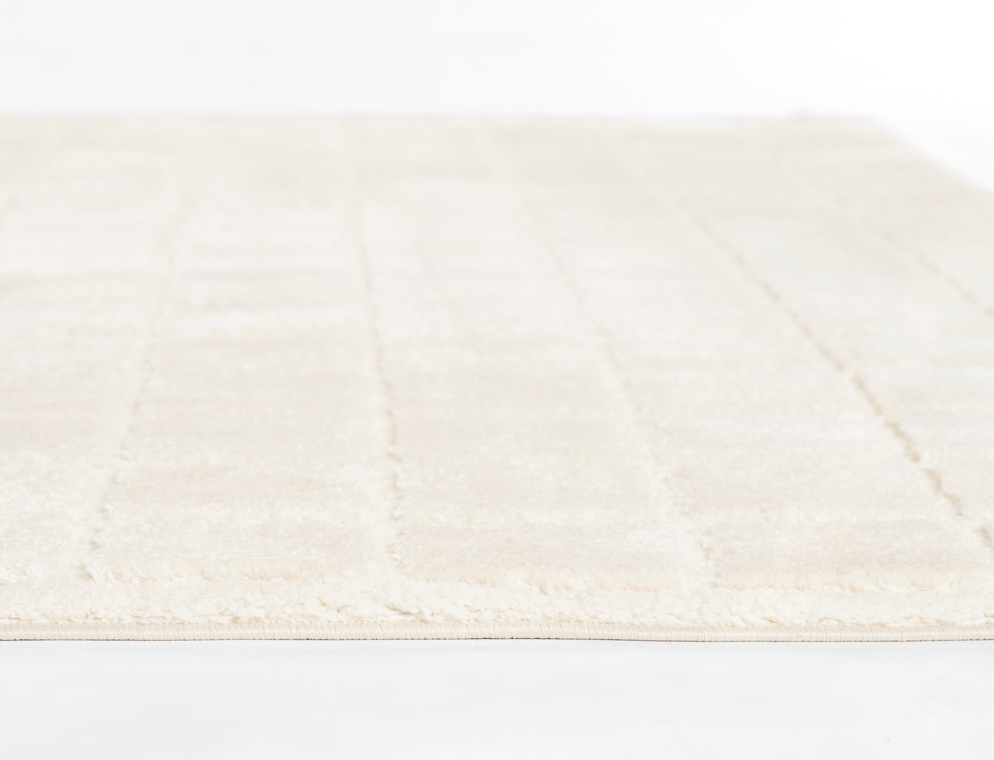 Ivory flat-weave rug with subtle geometric stripes and fringed edges.