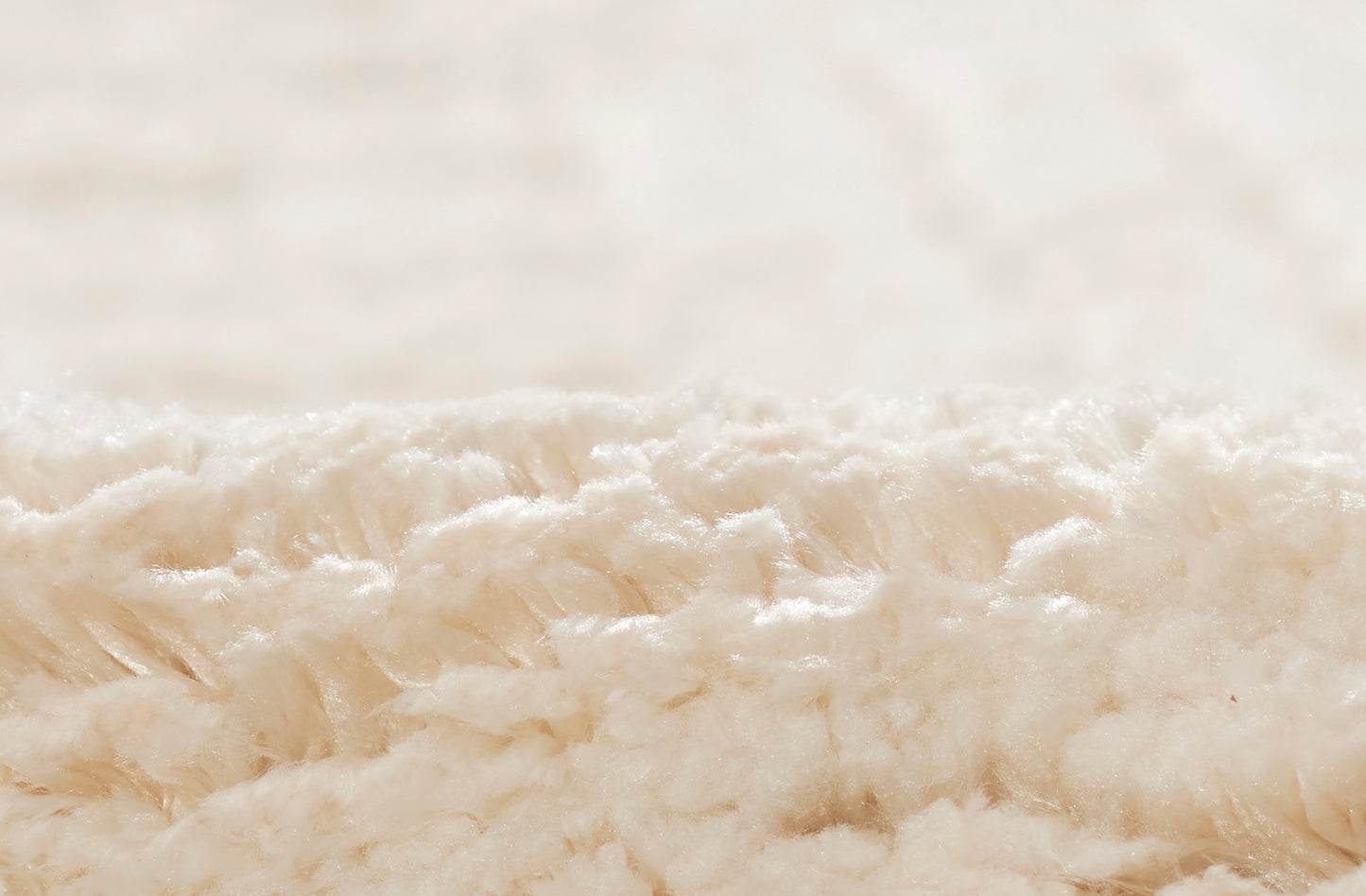 Cream sherpa plush rug close-up showing soft, fluffy fleece texture.