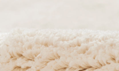 Cream fluffy shag blanket close-up, plush microfiber texture for cozy home decor.