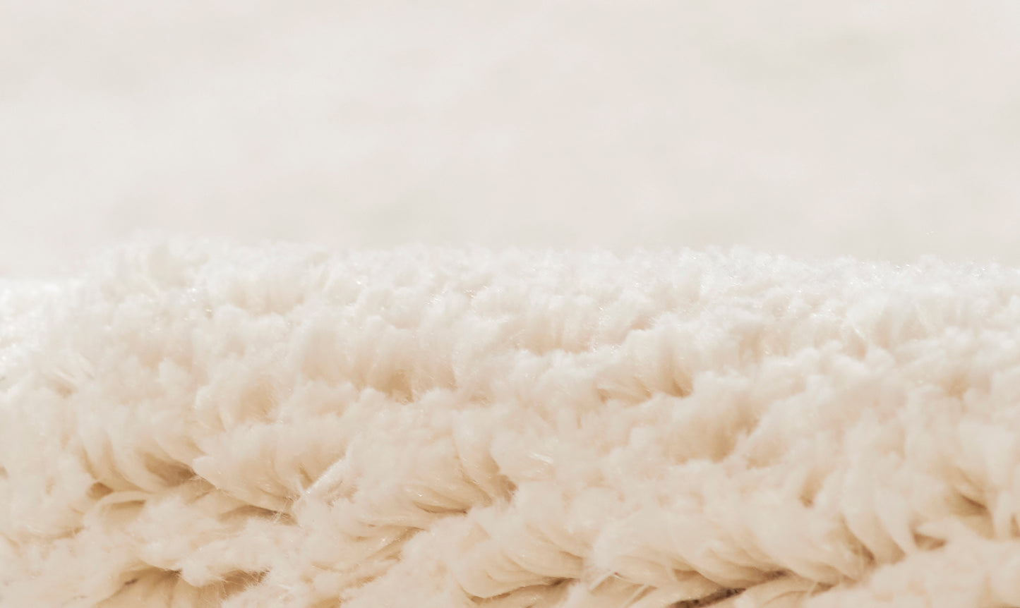 Cream fluffy shag rug close-up with long plush fibers, cozy home decor.