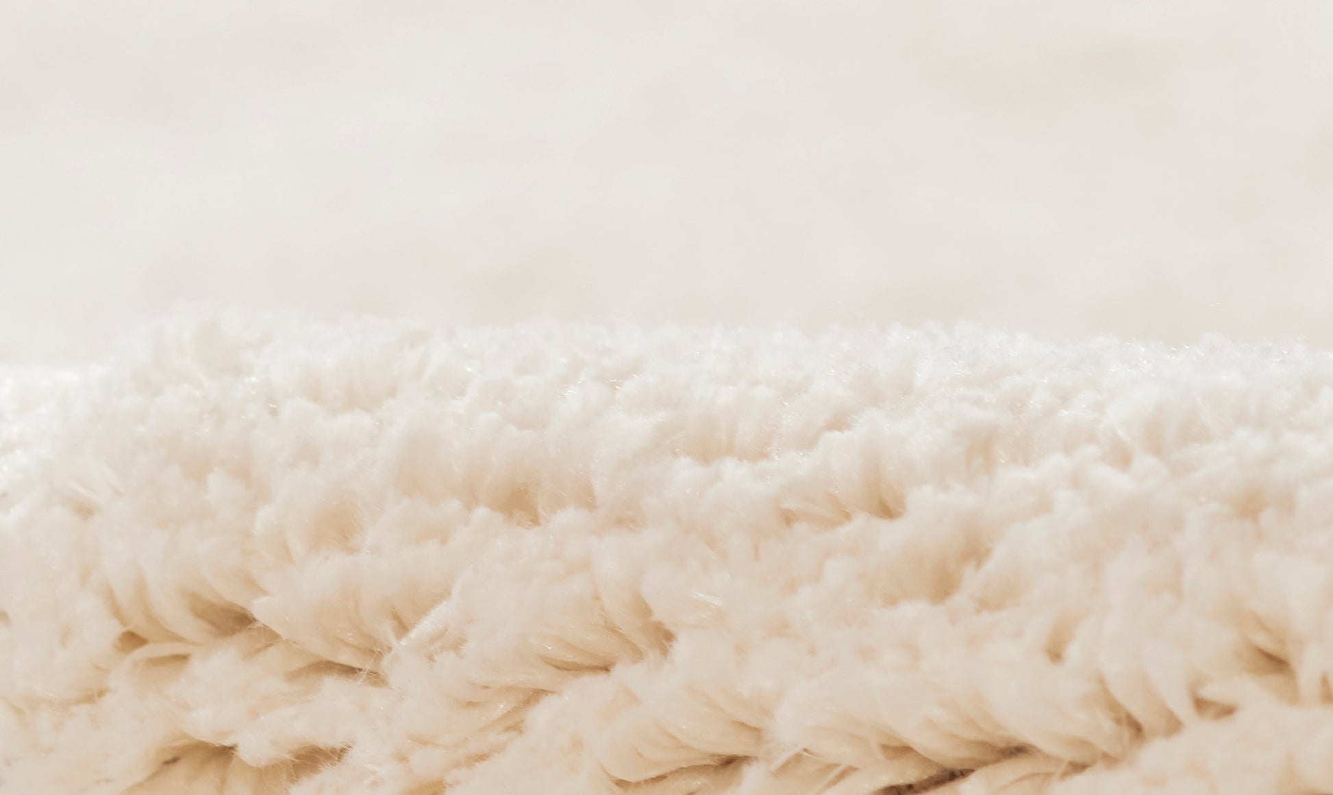 Cream fluffy shag rug close-up with long plush fibers, cozy home decor.