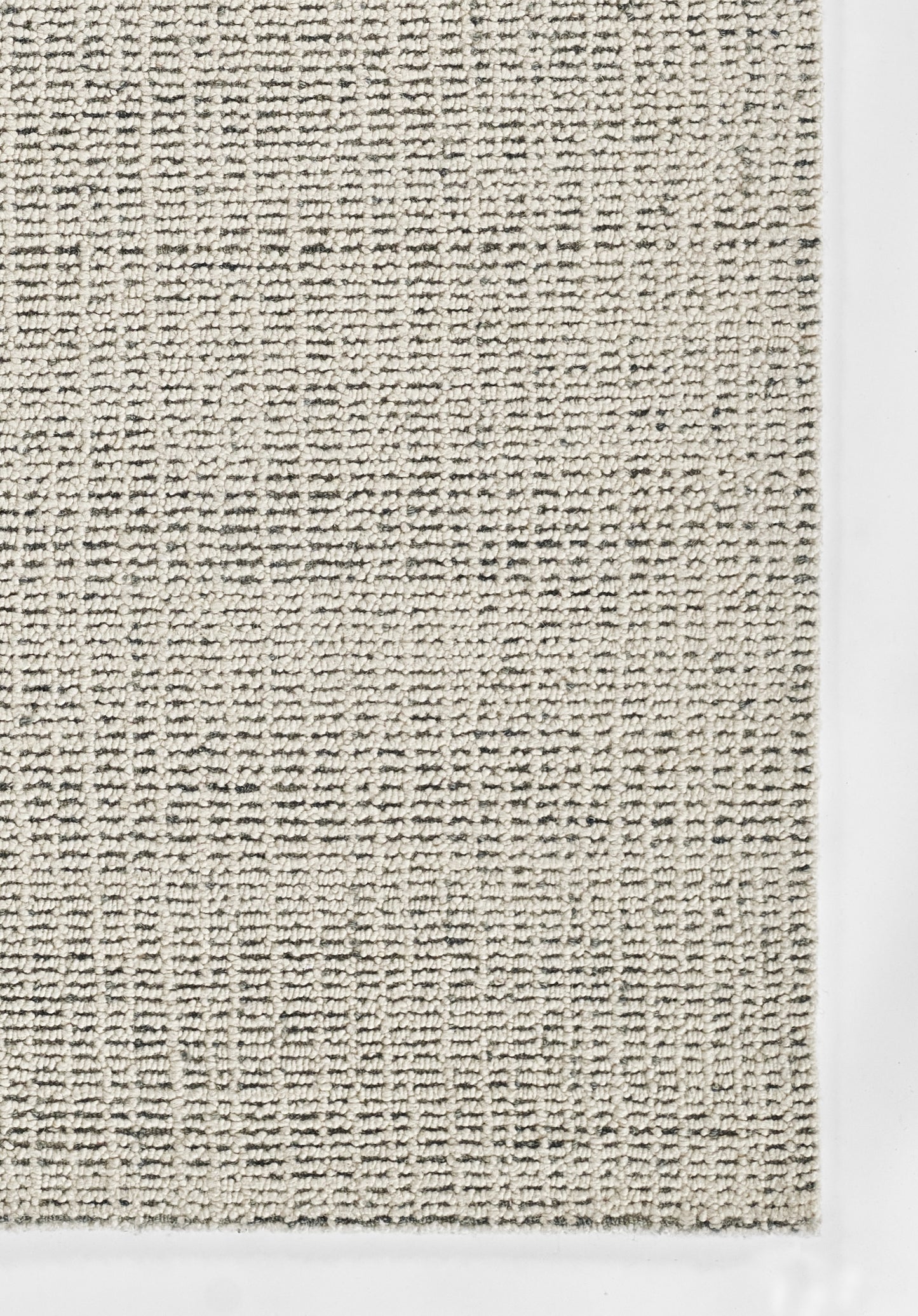 Beige woven rug with loop texture, subtle grid pattern and pale cream border.