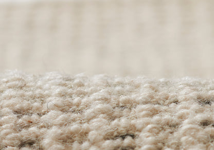 Close-up of beige loop-pile rug fibers with a soft texture, suitable for living spaces.