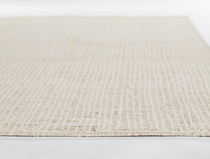 Beige flatweave rug with woven texture and natural-fiber look, close-up edge.